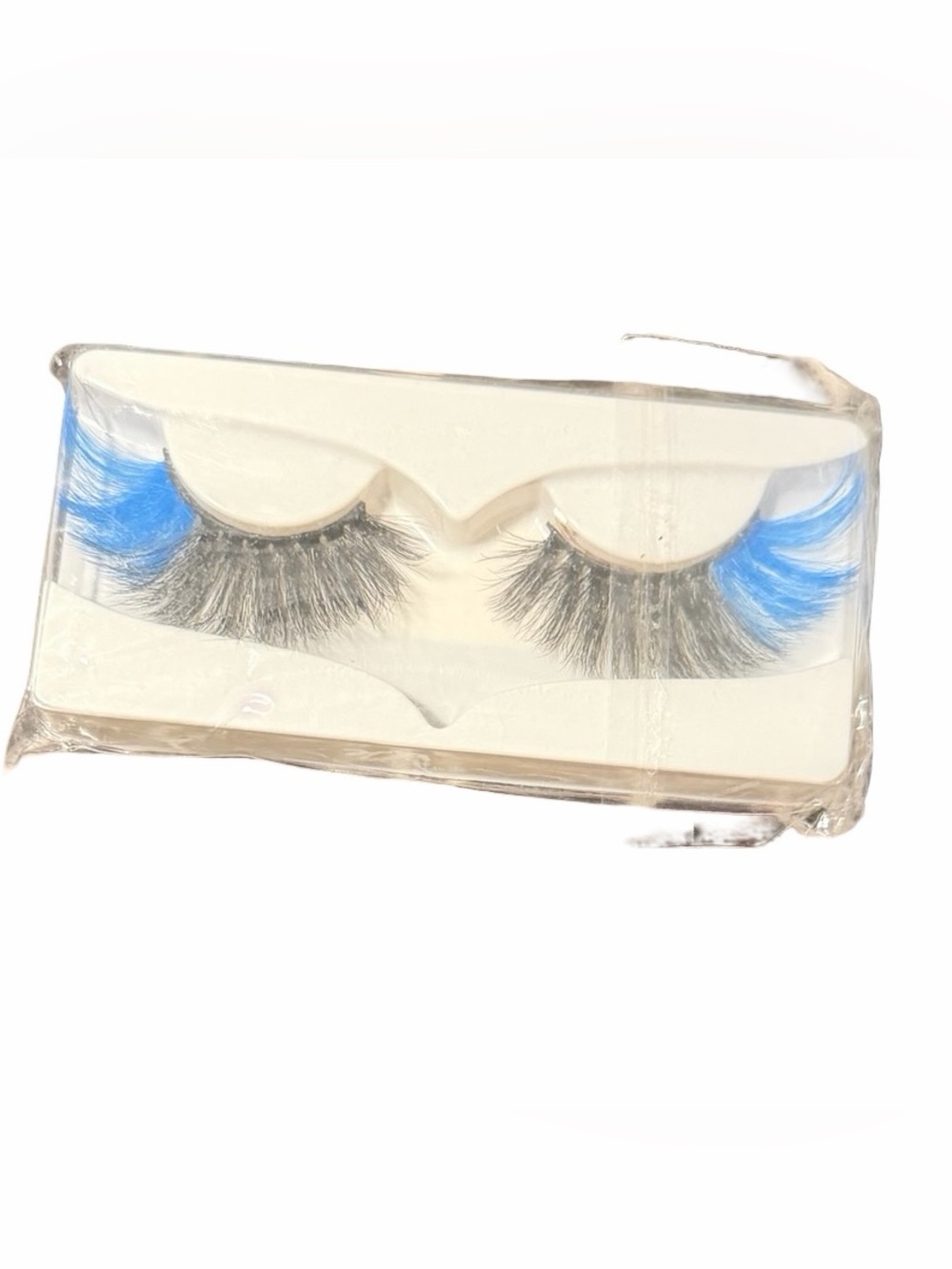Dramatic false eyelashes featuring a vibrant pop of blue on the outer tips